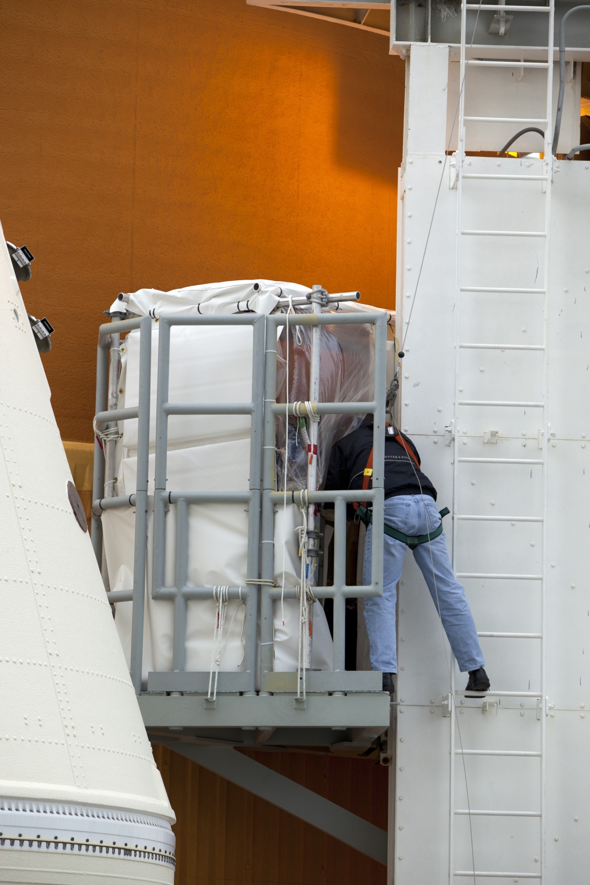 Large-format photograph: Technician midpoint between Left ET Access Platform and Guide Columns Ladder, demonstrating how they gained access to those Platforms.